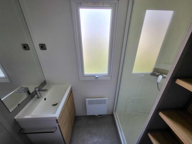 Salle d'eau composée d'un lavabo et d'une douche