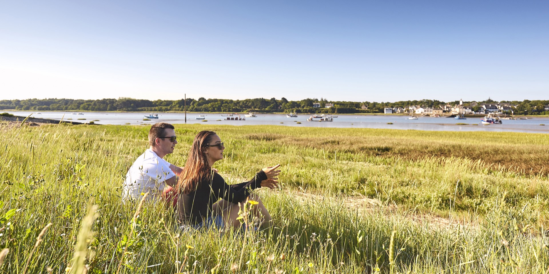 Couple assis dans l'herbe à la campagne